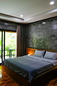 1 dormitorio con 1 cama con una pintura en la pared en Annie Meen's place Koh Yao Noi, en Ko Yao Noi
