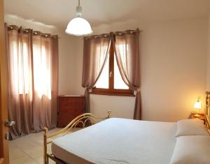 een slaapkamer met een bed en een raam met gordijnen bij Villetta Cece Bella vista sul Garda By Garda Domus Mea in Tremosine Sul Garda