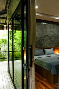 1 dormitorio con 1 cama y puerta corredera de cristal en Annie Meen's place Koh Yao Noi, en Ko Yao Noi
