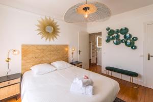 Un dormitorio con una cama blanca con una toalla. en Suites Mana - Le Manaloft ****, en Rethel