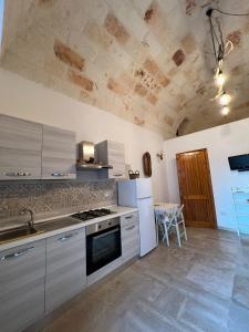 eine Küche mit einer Spüle und einem Herd Top-Backofen in der Unterkunft La Casetta in Polignano a Mare