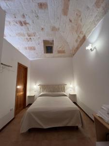 ein Schlafzimmer mit einem Bett in einem weißen Zimmer in der Unterkunft La Casetta in Polignano a Mare