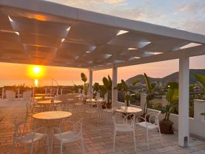a patio with tables and chairs and the sunset at infinity Castellabate b & b di Charme in Santa Maria di Castellabate