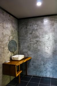een badkamer met een wastafel en een betonnen muur bij Annie Meen's place Koh Yao Noi in Ko Yao Noi