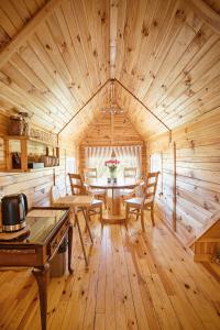Habitación de madera con mesa y sillas en una cabaña en Skansen Bicz Resort en Stare Miasto