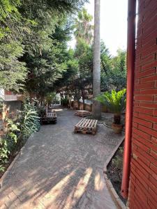 un patio con panchine e alberi e un edificio in mattoni di Vibo Apartment a Vibo Valentia