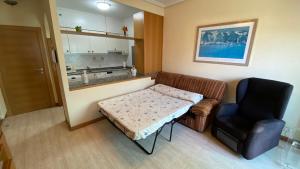a small room with a couch and a chair at Apartamento Playa Samil in Vigo