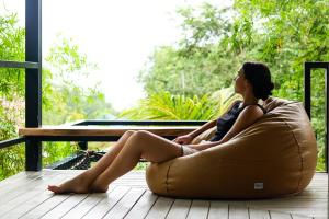 a woman sitting in a bean bag chair on a porch at Annie Meen's place Koh Yao Noi in Ko Yao Noi