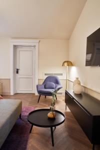 a living room with a blue chair and a table at Martis Forum Heritage Hotel & Residence in Poreč