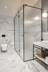 a bathroom with a shower and a toilet and a sink at Martis Forum Heritage Hotel & Residence in Poreč