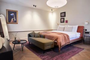 a bedroom with a large bed and a chair at Martis Forum Heritage Hotel & Residence in Poreč