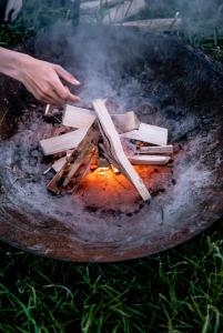 a person is cooking wood on a grill at Slow Cabin - Sint-Truiden in Sint-Truiden