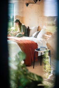 una mujer sentada en una cama en una habitación en Slow Cabin - Sint-Truiden, en Sint-Truiden