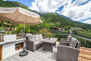 un patio con mesa, sillas y sombrilla en Rasnerhof Ferienwohnung Panorama, en Lagundo