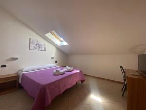 sypialnia z łóżkiem z fioletowym kocem w obiekcie Hotel Dream w Rimini