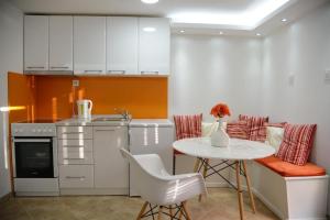 a kitchen with a white table and a table and chairs at Stylish basement with sea-view patio in Dobrota