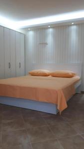 1 cama con sábanas y almohadas de color naranja en una habitación en Stylish basement with sea-view patio, en Dobrota