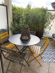 a table and chairs on a balcony with plants at Petit cocon douillet avec terrasse in La Rochelle