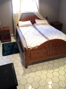 a bedroom with a wooden bed with a window at Basement Apartment Varadero in Lyngdal