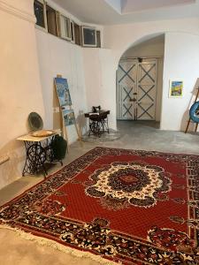 una stanza con un tappeto rosso sul pavimento accanto a una porta di Palazzo Porta a Procida
