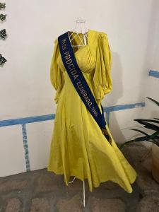 un vestito giallo su un appendiabiti con nastro blu di Palazzo Porta a Procida