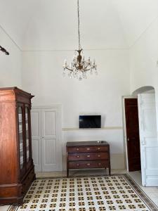 een kamer met een dressoir en een kroonluchter bij Palazzo Porta in Procida