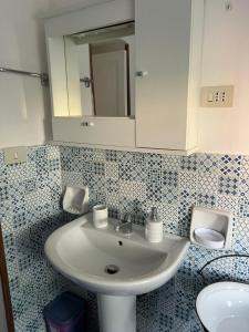 un bagno con lavandino e specchio di Palazzo Porta a Procida Altre 37 foto