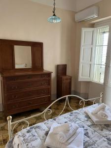 a bedroom with a bed with a dresser and a mirror at Palazzo Porta in Procida