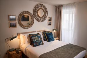 a bedroom with a bed with two pillows and a mirror at Hotel Cruzeiro in Angra do Heroísmo