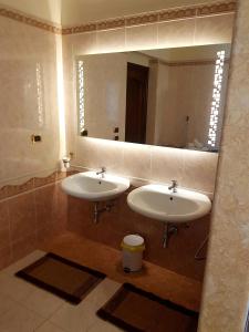 uma casa de banho com 2 lavatórios e um espelho grande em La Suerte em Sant'Egidio del Monte Albino