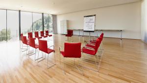 a conference room with red chairs and a table at Landhotel Atzmüller in Waxenberg