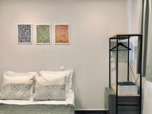 アテネにあるNavitas Houseのベッドルーム1室(ベッド1台付)が備わります。壁に3枚の写真が飾られています。
