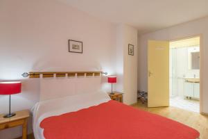 Un dormitorio con una cama roja y blanca y un baño. en Logis de l'Orme, en La Rochepot