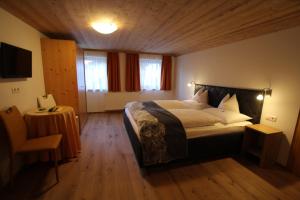 a bedroom with a large bed and a table at Haus Mathies in Stuben am Arlberg