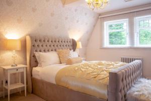 a bedroom with a large bed and a chandelier at Stunning 4 bedroom country house - Hot Tub & Sauna in Glasgow