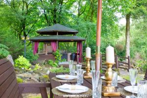 a table with plates and candles and a gazebo at Stunning 4 bedroom country house - Hot Tub & Sauna in Glasgow