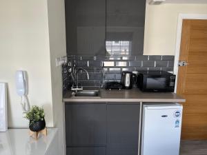 a kitchen with a sink and a microwave at Pods of Kings Cross - 6 in London