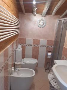 a bathroom with a toilet and a clock on the wall at Splendido rustico shabby in Capannori +53 photos