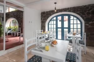 a dining room with a white table and chairs at Hostal North Seymour in Puerto Ayora