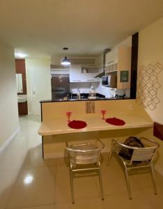 cocina con encimera, 2 sillas y mesa en apart-hotel Golden Lake, en Arraial do Cabo