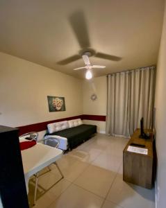 1 dormitorio con 1 cama y ventilador de techo en apart-hotel Golden Lake, en Arraial do Cabo