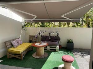 a patio with a table and a couch at Appartement avec terrasse proche de Rennes in Saint-Jacques-de-la-Lande