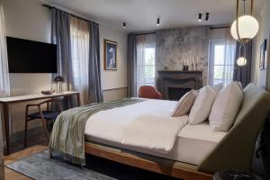 a bedroom with a bed and a desk and a television at Martis Forum Heritage Hotel & Residence in Poreč