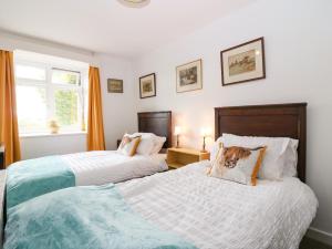 a bedroom with two beds with a dog pillow on them at Charlies Cottage in Duns