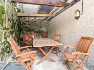 a wooden table and chairs on a patio at Charlies Cottage in Duns