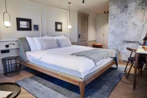 a bedroom with a large bed with white sheets and pillows at Martis Forum Heritage Hotel & Residence in Poreč