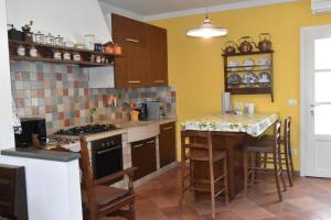 a kitchen with yellow walls and a counter top at Ai ciliegi in Concordia Sagittaria +6 photos