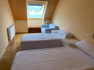 een kamer met 2 bedden, een bank en een raam bij Apartamentos Illa Nova in Foz