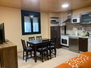 een keuken met een tafel en stoelen in een kamer bij Apartamentos Illa Nova in Foz