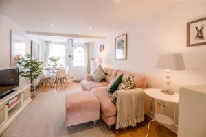 a living room with a couch and a table at Holly Cottage in Bury Saint Edmunds